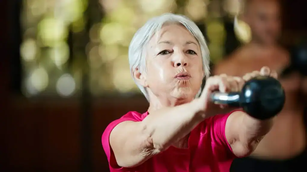 Toning Arms After 60: Empowering Womens Fitness Through Effective Weight Training 1 Older woman doing weight training Harefield to help her strength and longevity