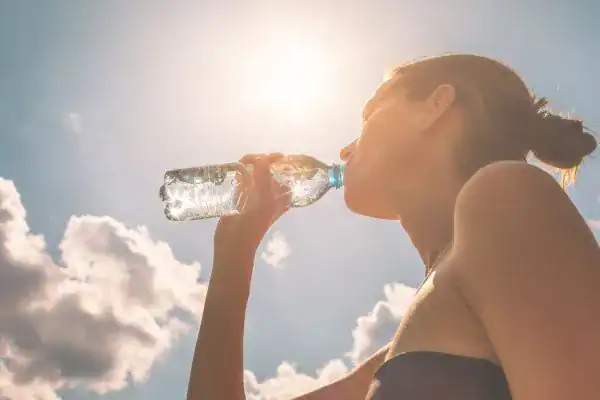 Hydration: The Secret Ingredient for a Toned Stomach and Enhanced Fitness 3 Image of woman drinking water to hydrate Harefield after run.
