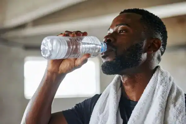 Hydration: The Secret Ingredient for a Toned Stomach and Enhanced Fitness 1 Image of man drinking water to improve hydration Harefield after work out.